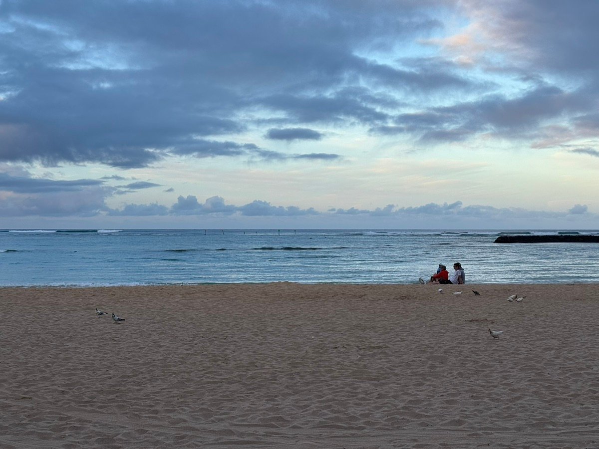Calm waters of Ala Moana Beach with distant surfers