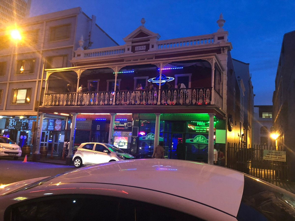 长街啤酒屋的立面，带有黄色装饰和阳台。