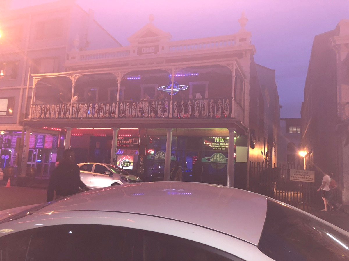 长街上的户外用餐区，顾客在夜晚享受饮品。