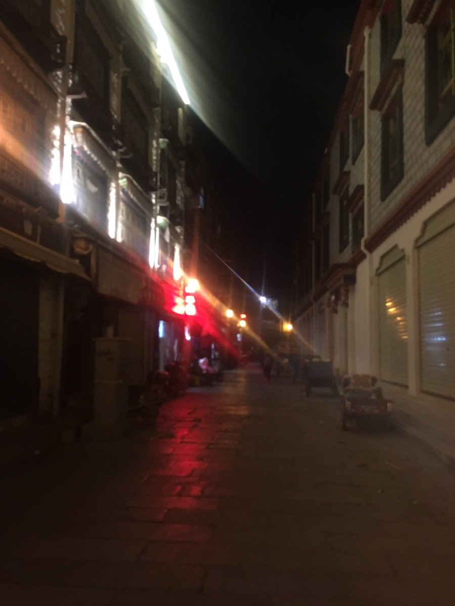 People walking on a illuminated street at night