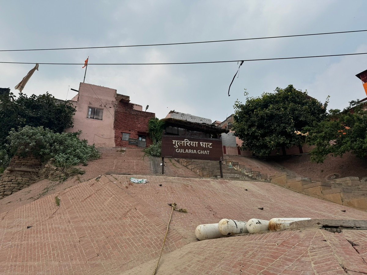 瓦拉纳西河坛沙滩上部分埋藏的大型管道，背景是河流