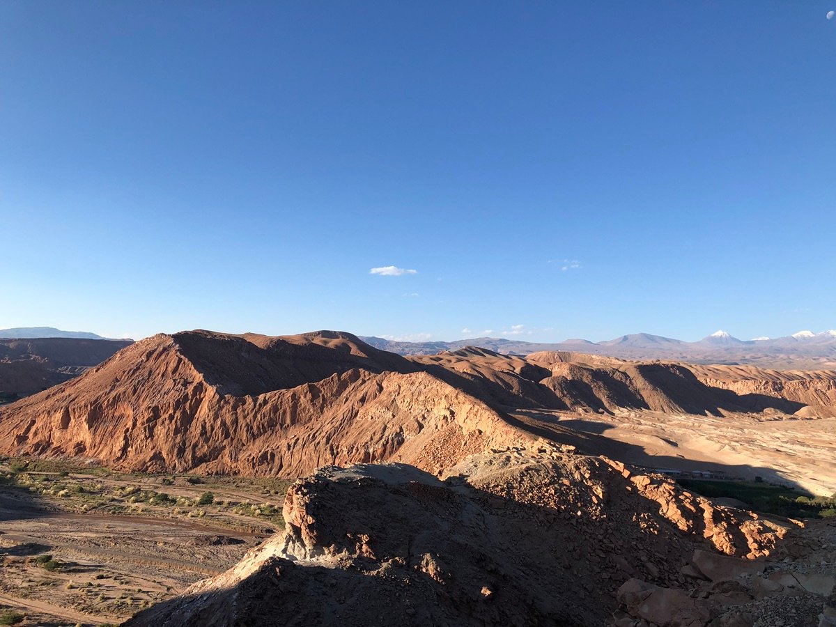 阿塔卡马沙漠圣佩德罗河谷的全景，阳光普照的悬崖和谷底的聚落。