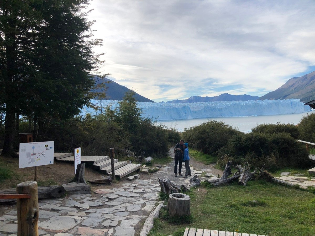 一对夫妇站在佩里托莫雷诺冰川前的小径上。