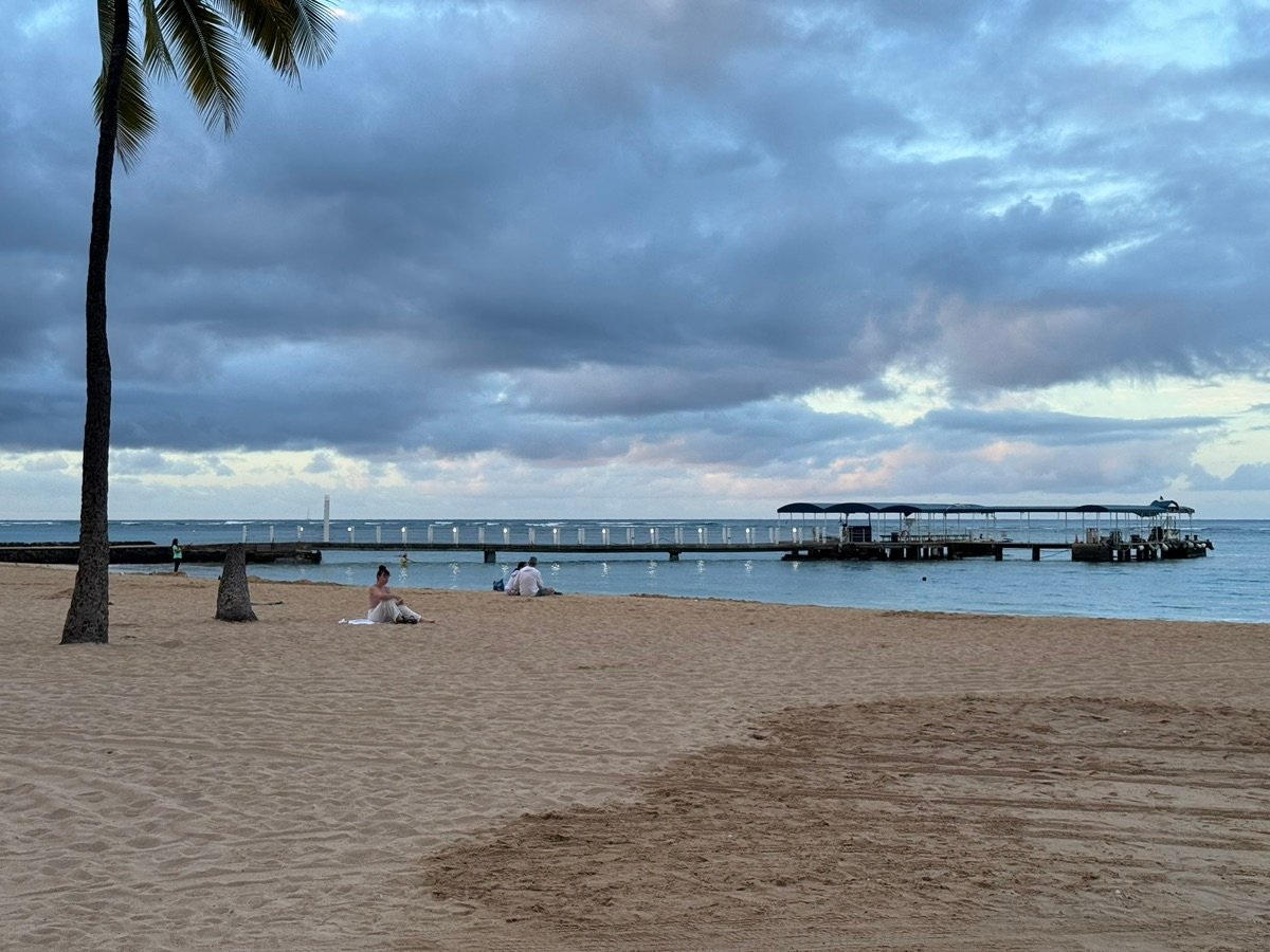 People relaxing on the beach near the breakwater