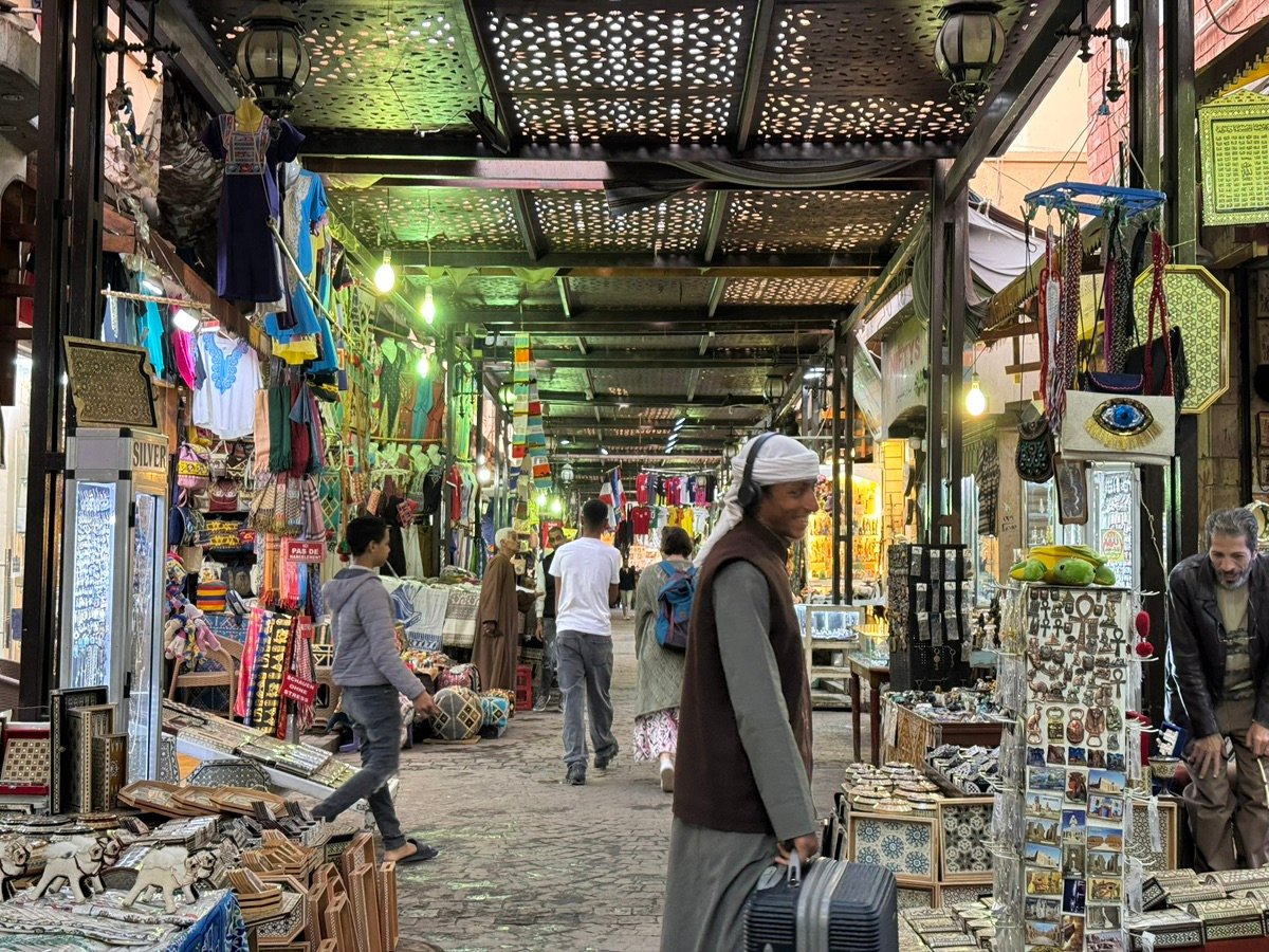 开罗汗哈利利集市左侧摊位的特写，展示着印有埃及符号的T恤和传统织物