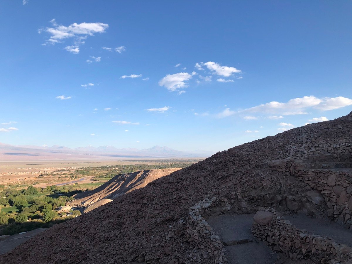 阿塔卡马沙漠的山谷景色，远处是山脉，前景是河流和聚落。