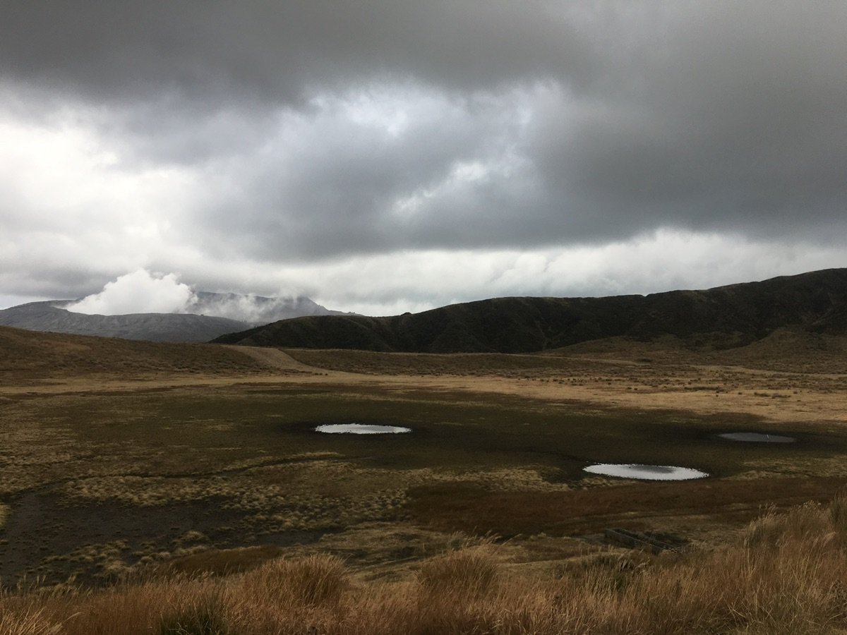 People hiking on Kusasenri-ga-hama plain in Aso Caldera