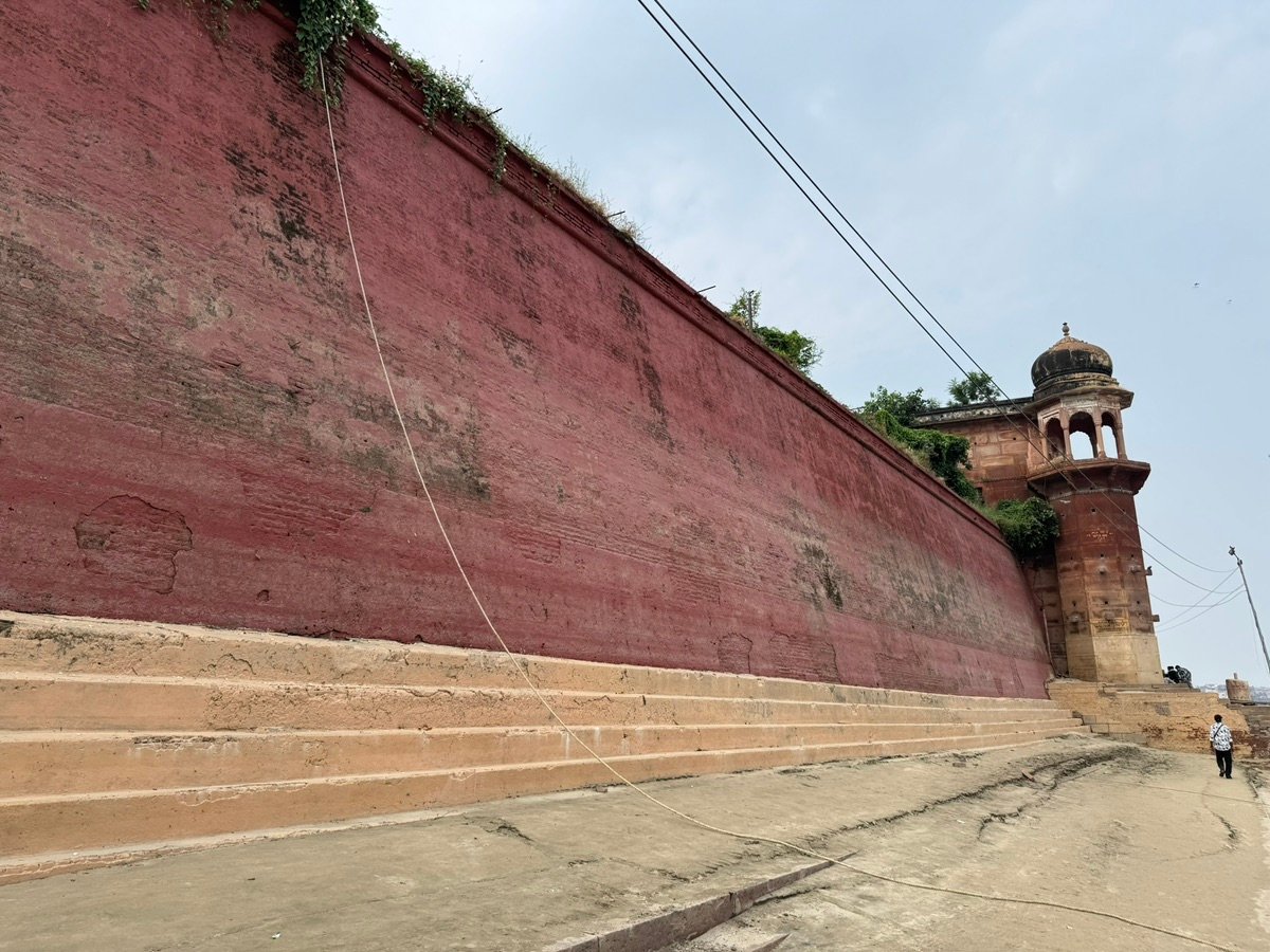 人们在瓦拉纳西河坛上行走，古老建筑从河岸升起