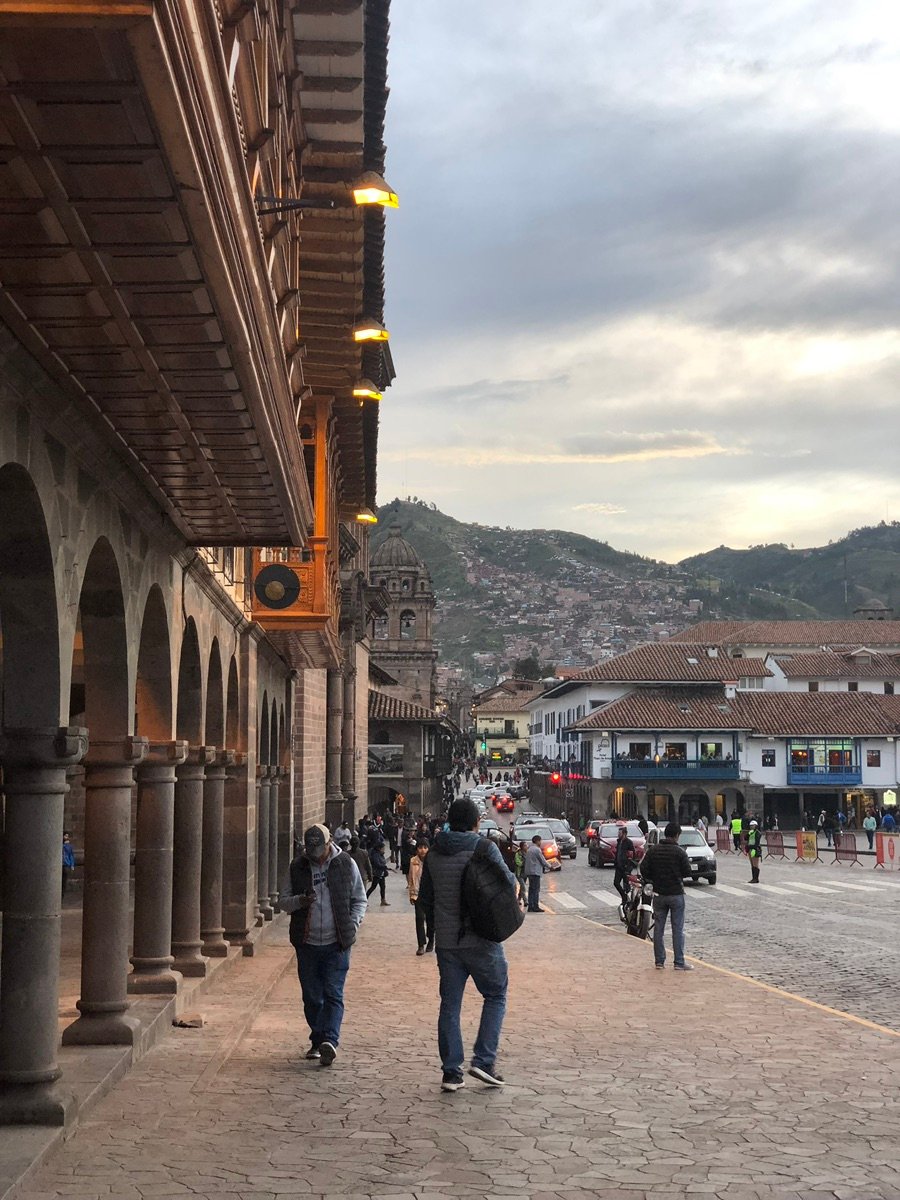 People walking around Plaza de Armas with historic buildings in the background