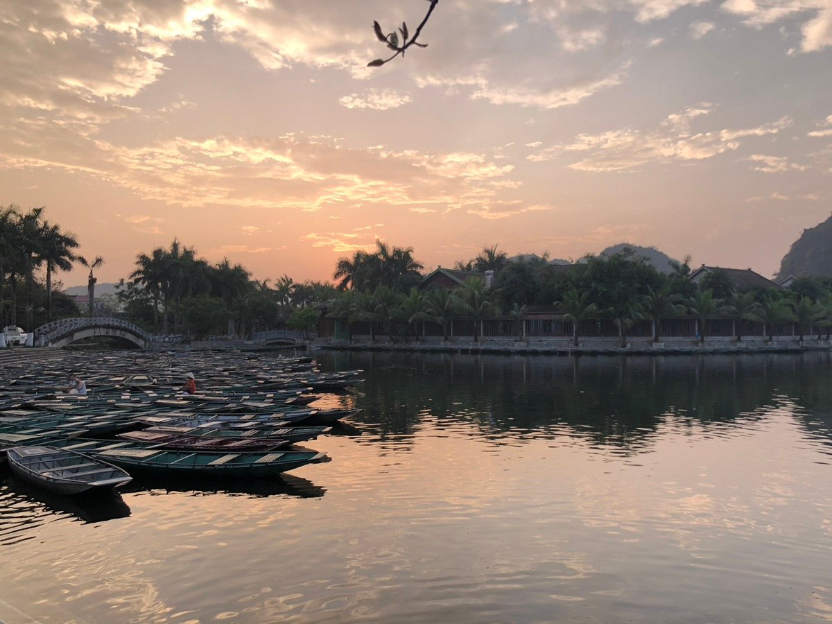 Boats lined up at the Tam Coc dock during sunset