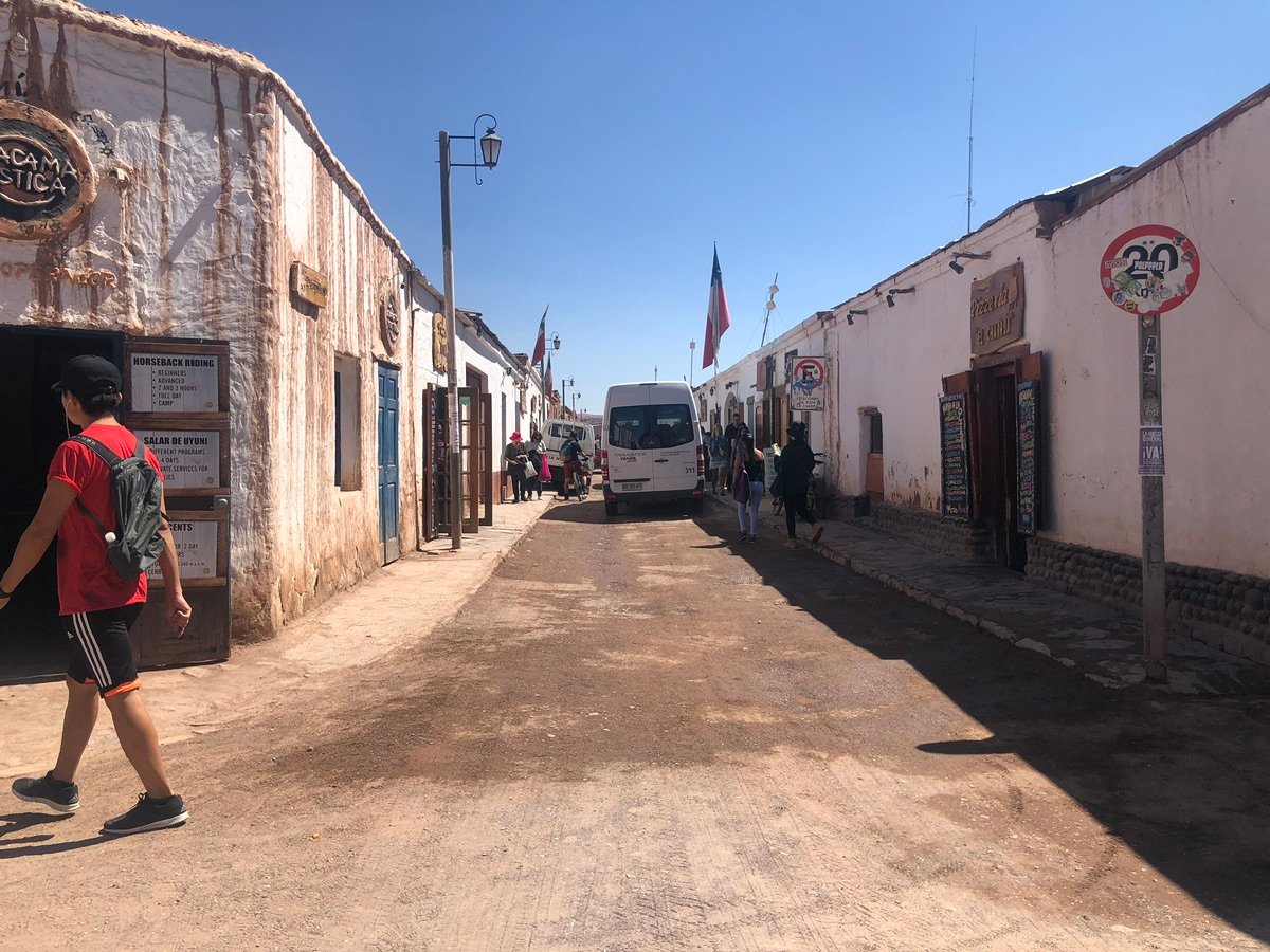 Una calle polvorienta flanqueada por edificios tradicionales en un pueblo desértico