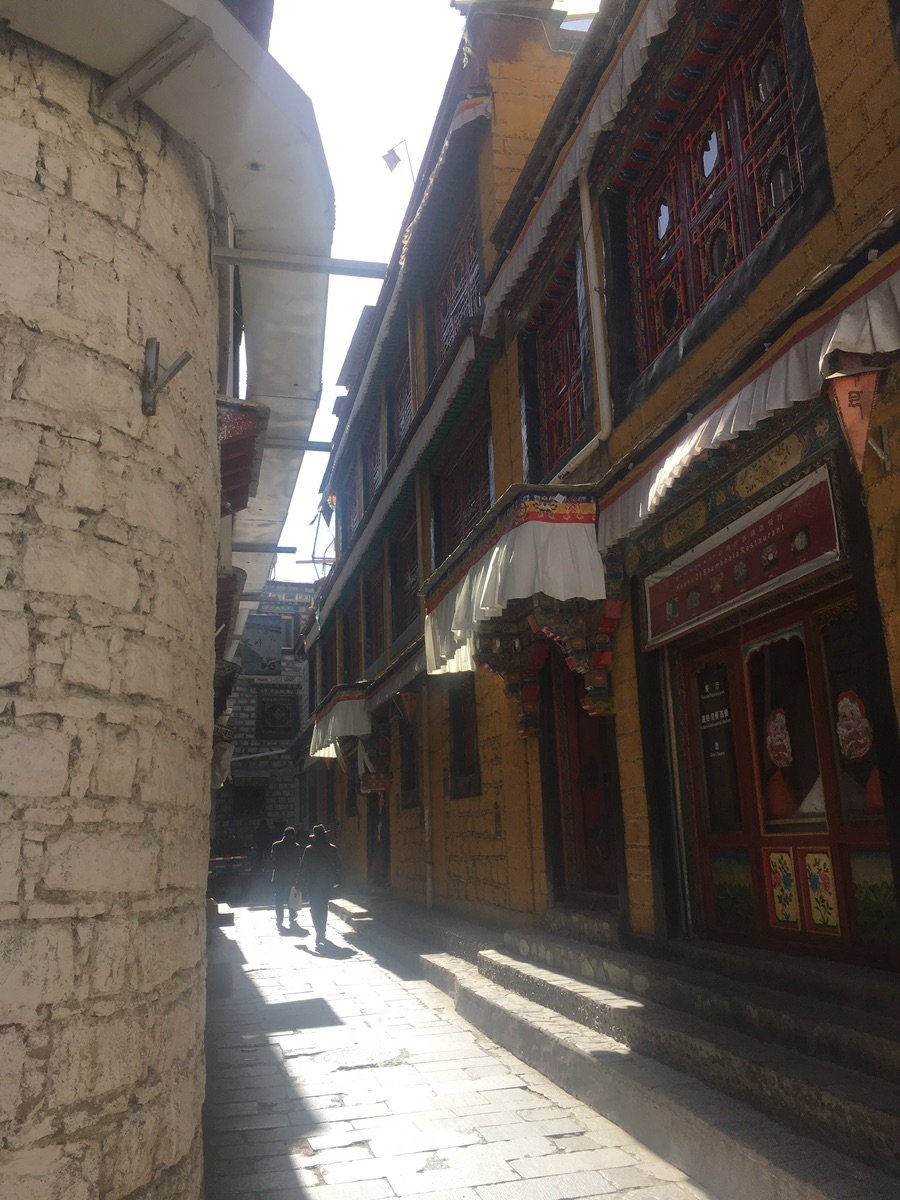 拉萨八廓街古老巷道，一盏藏式灯笼悬挂在石墙上