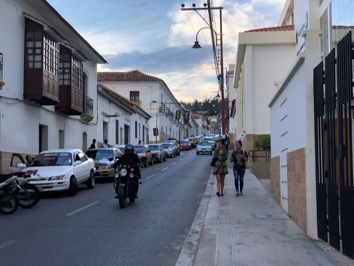 Close-up of white colonial building facade with arched window and decorative elements in Sucre