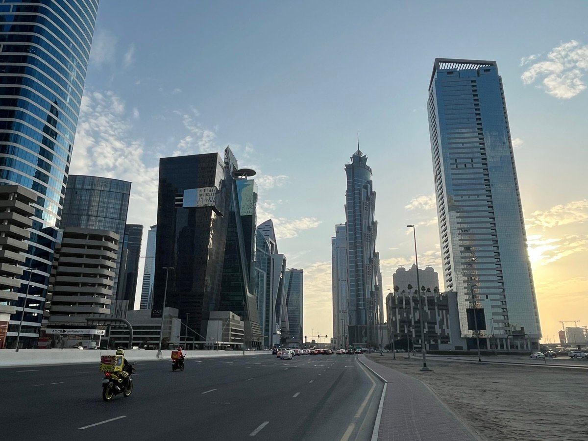 A multi-story white building, likely a parking structure, viewed from below in Dubai's urban landscape.