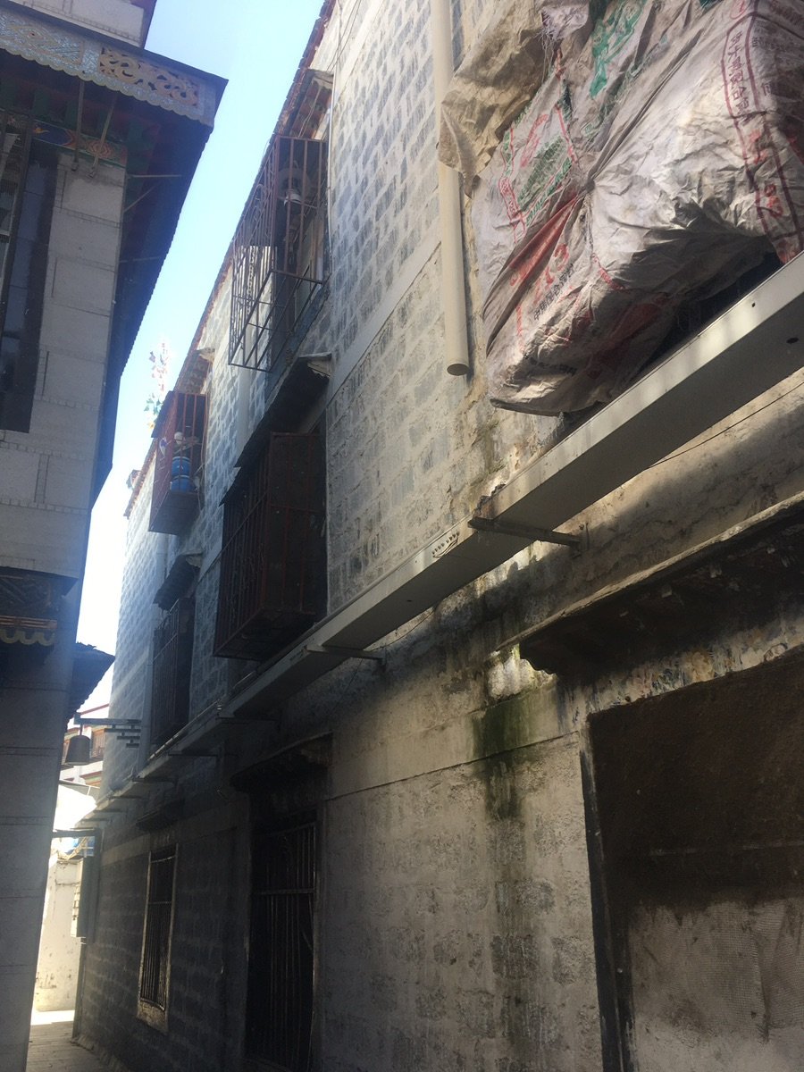 八廓街巷道中，行人与小货车