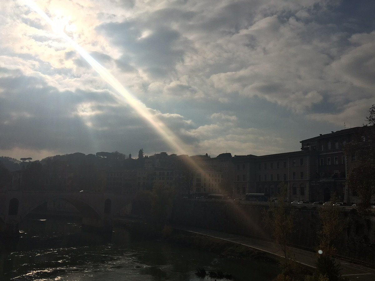 People walking on Ponte SantAngelo with Castel SantAngelo in the background
