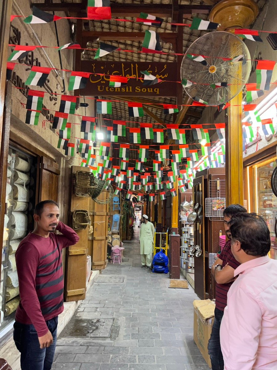 アル・シーフ・スークの木造屋根構造と吊り下げられたランタンの詳細な眺め。開口部から光が差し込んでいます。