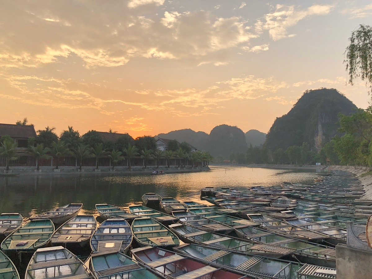 Woman rowing a boat with her feet in Tam Coc