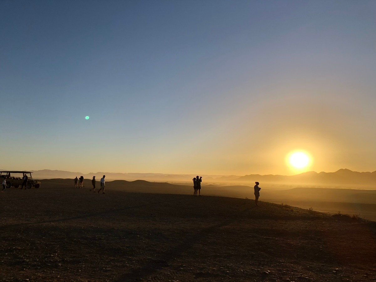 Amanecer en el desierto de Namib con montañas distantes y un cielo degradado