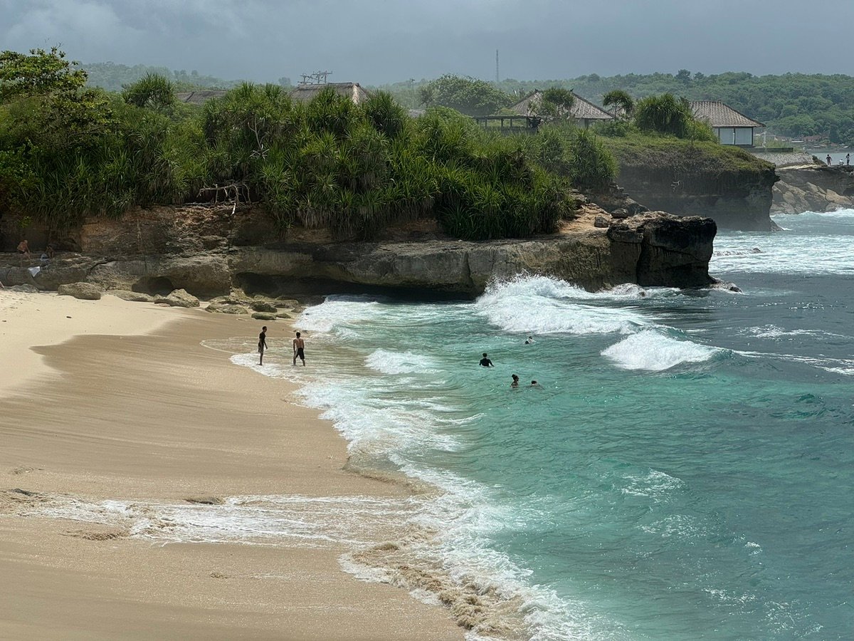 Playa de Secret Beach con olas y algunas personas en el agua