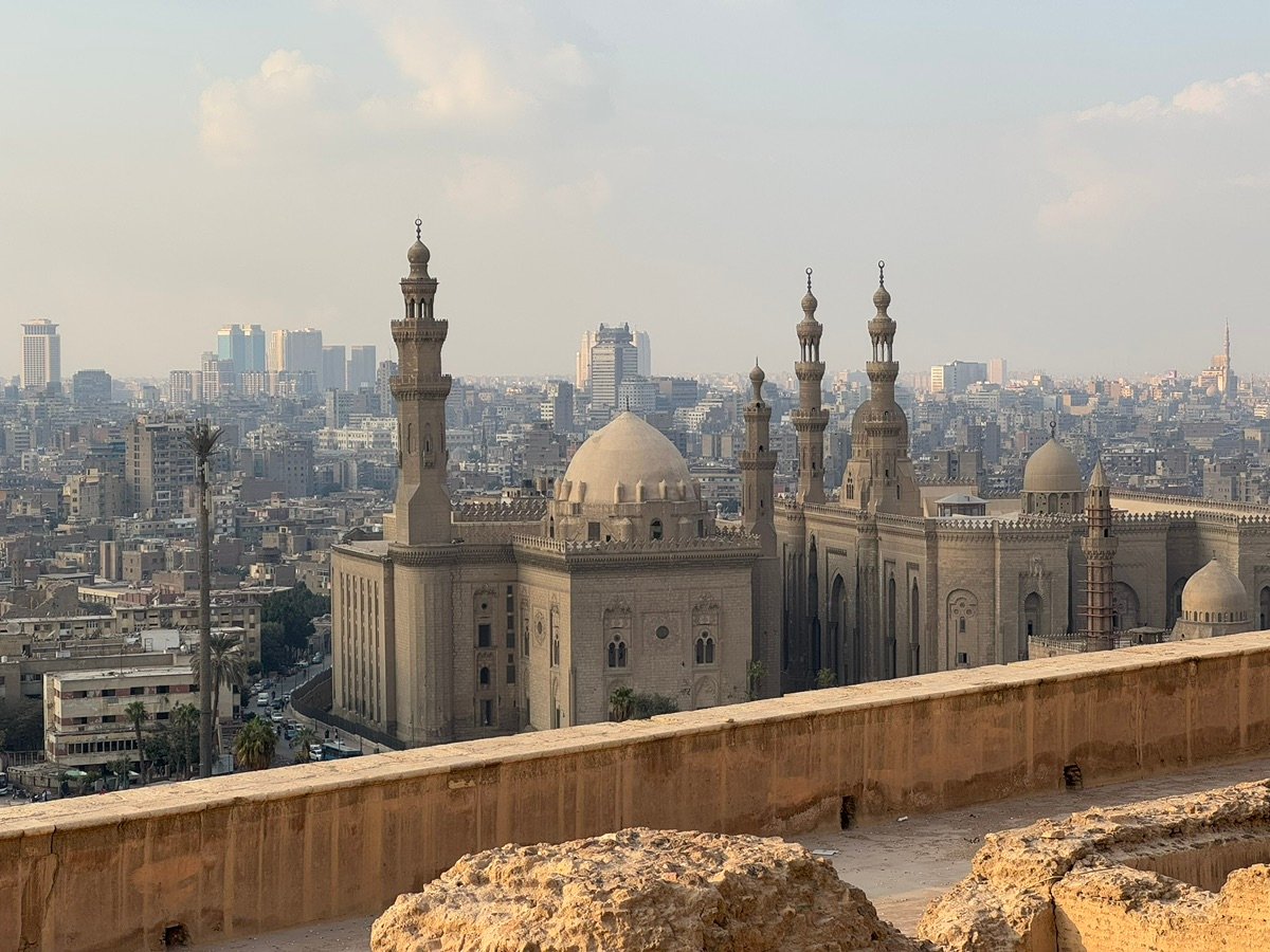 Upper section of the mosque with domes and minarets against a blue sky