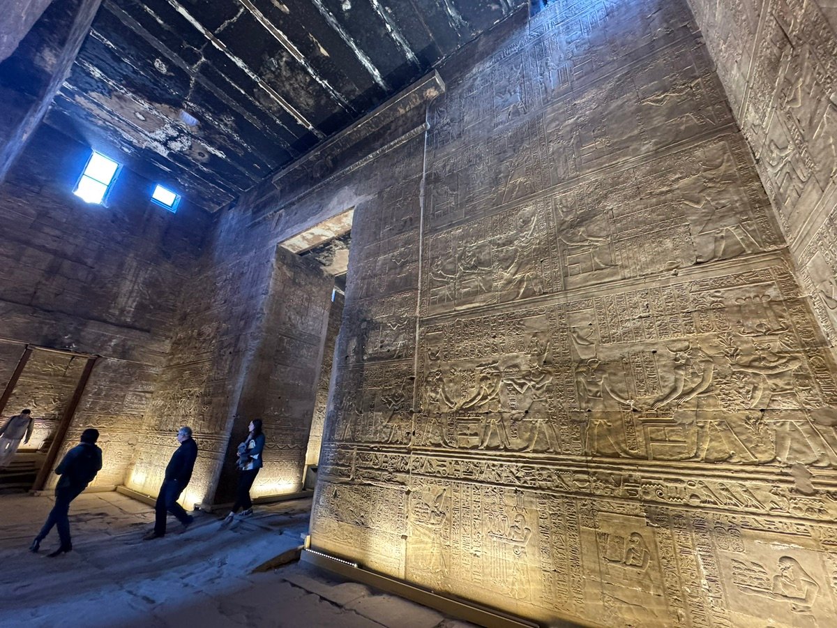 Visitors admire the ancient stone carvings inside Edfu Temple in Egypt.