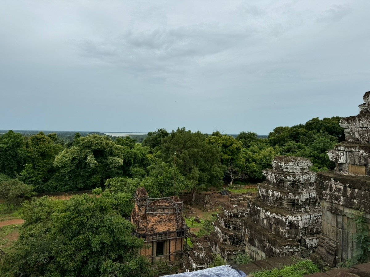 Ruinas de piedra de Phnom Bakheng rodeadas de un frondoso bosque.