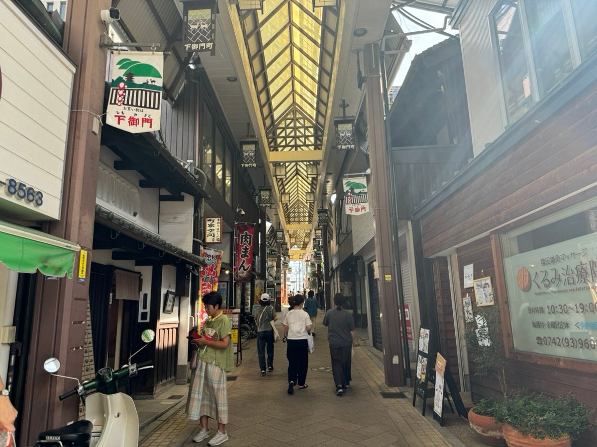 People walking through the covered Shimomikado Shopping Street in Nara, Japan.