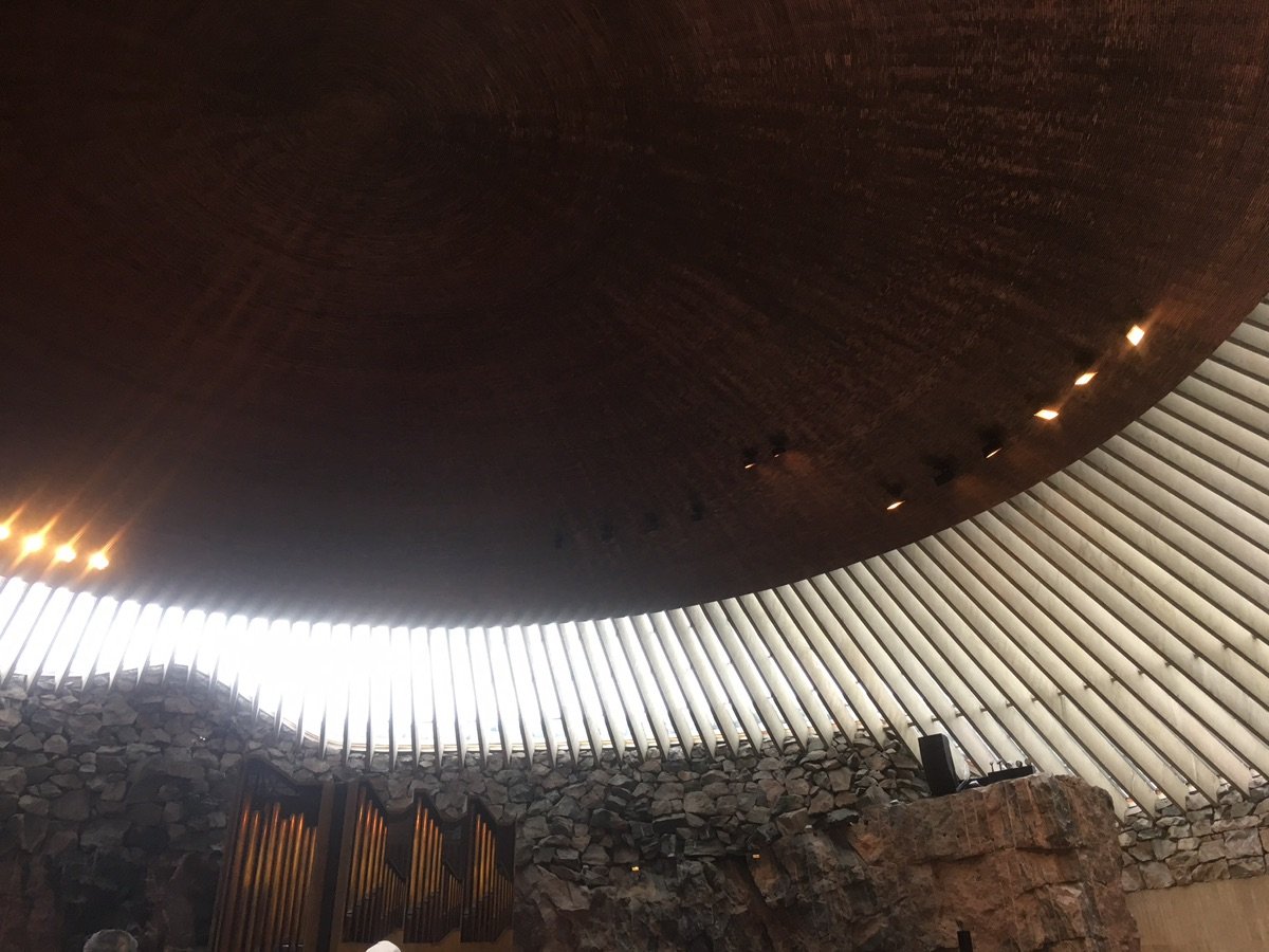 Looking up at the copper dome and stone walls inside Temppeliaukio Church.