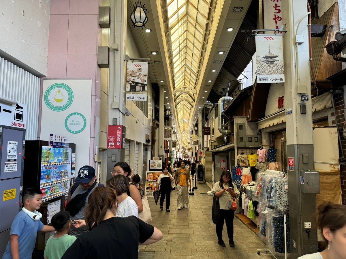 People walking through a covered shopping arcade in Nara, Japan.