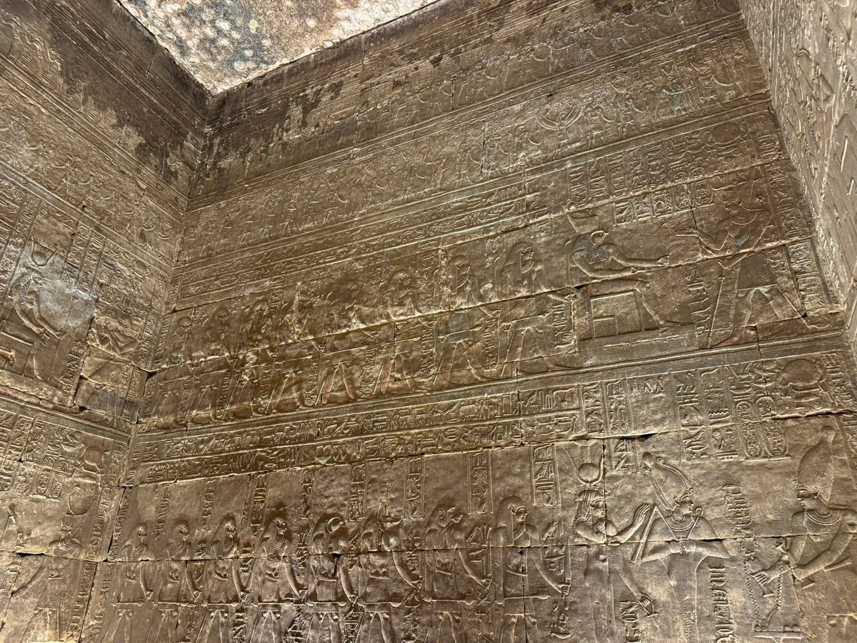 Detailed relief carvings and hieroglyphs on the stone walls of Edfu Temple.