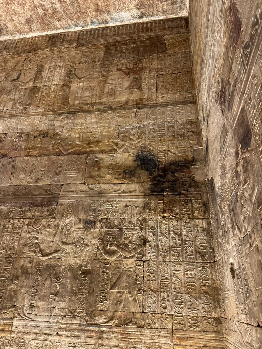 Detailed carvings and hieroglyphs on the stone walls of Edfu Temple.
