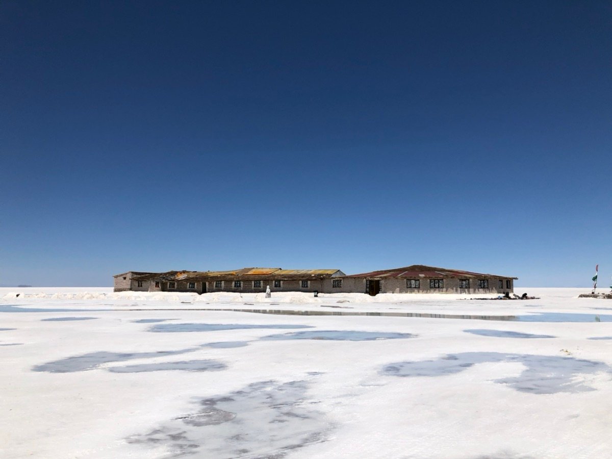 A building stands on the vast white salt flats of Salar de Uyuni.